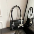 Schwarze Leder-Umhängetasche mit Schleife, stilvolle französische Damen-Achseltasche. - Mit Anhänger / Schwarz
