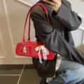 Rote Lackleder Achseltasche für Damen, schicke Baguette Umhängetasche mit Schleife und Anhänger. - Mit Anhänger / Rot