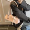 Rosa Lackleder Baguette Schultertasche mit eleganter Spitzen-Schleife und schickem Design. - Mit Anhänger / Rosa