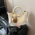 Weiße schicke Handtasche mit geflochtenem Griff und süßem Bären-Anhänger Umhängetasche. - Mit Anhänger / Gebrochenes Weiß