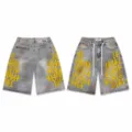 Detailed view of distressed denim shorts with embroidered numbers and stylish paint splatters. - 38 / Bottoms / Yellow