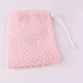 Gros plan detail d'un filet moussant de savon rose avec une fermeture a cordon blanc. - Grille Rose
