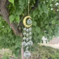Gros plan détail prisme attrape-soleil en cristal suspendu avec pendentif lune dorée perles. - Lune Pendentif d'Éclairage Transparent