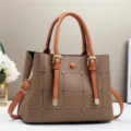 Nahaufnahme der stilvollen braunen Ledertasche mit Steppnähten und Metallschnallendetails. - Braun