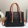 Vista ravvicinata e dettagliata di una borsa in pelle nera con manici marroni. - Nero