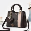Vista dettagliata della borsa a spalla marrone in pelle con motivo monogramma e manico intrecciato. - Lettera grande caffè