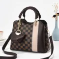 Vista dettagliata della borsa a tracolla a quadretti marrone con manico intrecciato e mini pochette. - Plaid