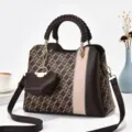 Vista dettagliata della elegante borsa a tracolla marrone con manico intrecciato e ciondolo. - Motivo a V Caffè