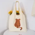 Canvas tote bag detail showing cute tiger back graphic and sunflower prop in a clean setup. - Inner Pocket Button Style / Trailing Tail Tiger Bag
