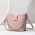 Vue de détail d'un élégant sac seau rose pour femme avec une chaîne en métal argenté. - 24x10x21cm / Rose