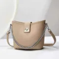 Dettaglio borsa secchiello beige minimalista con tracolla a catena e serratura triangolare unica. - 24x10x21cm / Kaki