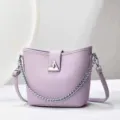 Primo piano dettagliato dell'elegante borsa a secchiello lavanda con tracolla in catena. - 24x10x21cm / Viola