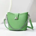 Détail de sac seau vert montrant une texture en cuir premium et une élégante chaîne argentée. - 24x10x21cm / Vert