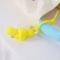 Canvas bucket bag detail view featuring a cute yellow knot plush pendant and light blue accessory charm. - Yellow Knot Pendant