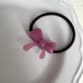 Detalle chic de coletero con lazo de acetato morado, accesorio elegante para coletas de pelo. - Rosa