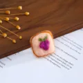 Close-up detail of the cute toast-shaped wool felt DIY handmade hair clip accessory. - Grape Bread