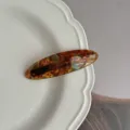 Tortoise shell acetate hair clip detail shot, vintage oval design hairpin for elegant hairstyles. - Wild Green