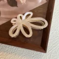 Vista dettagliata della molletta per capelli in acetato con fiore cavo, design bianco. - 7cm / Champagne