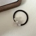 Primer plano detallado de coletero francés retro de acetato con flor, perla y goma elástica. - Blanco