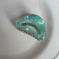 Gedetailleerd overzicht van een trendy groene acetaat haarklem met zeemeermin glans. - 4.50cm / Sterrenhemel Groen