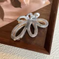 Primo piano dettagliato del fermaglio per capelli grigio marmorizzato dal design floreale. - 7cm / grigio-bianco