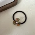 Detail shot of a French vintage acetate flower hair tie with pearl accent for elegant hairstyles. - Dusty Pink