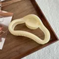 Vista detallada de la elegante pinza de pelo geométrica irregular en suave color crema. - 11.5cm / Amarillo gelatina