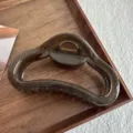 Primer plano detallado de una pinza para el pelo geométrica oscura en una bandeja de madera. - 11.5cm / Gris Gelatina