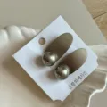 Primer plano de pinza de pelo ovalada de metal con bola, elegante accesorio de flequillo. - 4.50cm / Gris