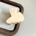 Close-up detail shot of the elegant beige acetate hair claw clip, featuring a unique design. - 4.50cm / Off White
