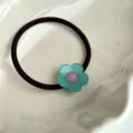 Détail de chouchou floral mignon, avec bande élastique noire et fleur vert menthe. - Bleu