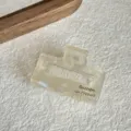 Vista detallada de una pequeña pinza de acetato para el pelo con textura nacarada. - 4.3cm / Blanco Hada