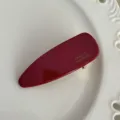 Primer plano detallado del pasador de pelo de acetato rojo oscuro con impresión dorada. - 6cm / Burdeos
