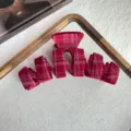 Close-up view of red plaid velvet hair claw clip detail, showing soft textured fabric and teeth. - Backbone Style / Burgundy