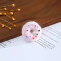 Wool felt donut shape craft detail view with colorful bead embellishments for DIY decoration. - Purple Donut