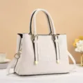 Vista dettagliata borsa bianca motivo coccodrillo, fibbie eleganti e tracolla in primo piano. - Bianco avorio