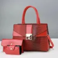 Borsa a mano in vernice rossa con stampa coccodrillo, chiusura metallica dorata e tracolla. - Rosso