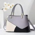 Vue détaillée du sac à main colorblock élégant avec un design gris, blanc et noir. - 28x12x29cm / Violet