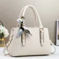 Vista dettagliata della borsa strutturata beige elegante con foulard in seta e dettagli. - Bianco avorio