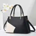 Primo piano che mostra il design bicolore elegante di questa borsa da donna chic. - 28x12x29cm / Nero