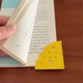 Primo piano di un segnapagina d'angolo in pelle gialla a forma di formaggio, cancelleria. - Giallo
