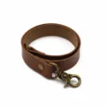 Minimalist brown leather curtain tieback with vintage bronze metal hooks and snap buckle. - Brown