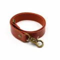 Minimalist brown leather curtain tieback with bronze metal lobster clasp and sturdy rivet details. - Red