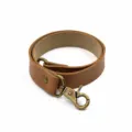 Brown leather curtain tie-back with antique bronze metal clasp for simple home window decor. - Light Brown