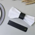 Dettaglio portatovaglioli in pelle PU, elegante supporto nero per decorazione tavola ristorante. - Nero