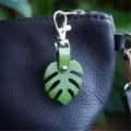 Green leather monstera leaf keychain and cute bag charm featuring stylish silver hardware. - Clasp Style Leaf Keychain / Green
