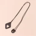 Detail of brown leather sunglasses strap with triangle pendant and metal snap button design. - Brown