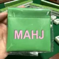 Gedetailleerde close-up van de groene PU lederen mahjong chip muntzak met handige sluiting. - Groen