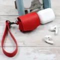 Red PU leather wireless earphone protective case with strap for daily carry and protection. - Red