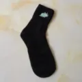 Close-up detail view of the cute blue embroidered dinosaur pattern on the black cotton sock cuff. - One Size / Black